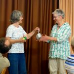 Rundgang Juni 2026: Brigitte überreicht Susanne und Dorothea ein Mikroskop